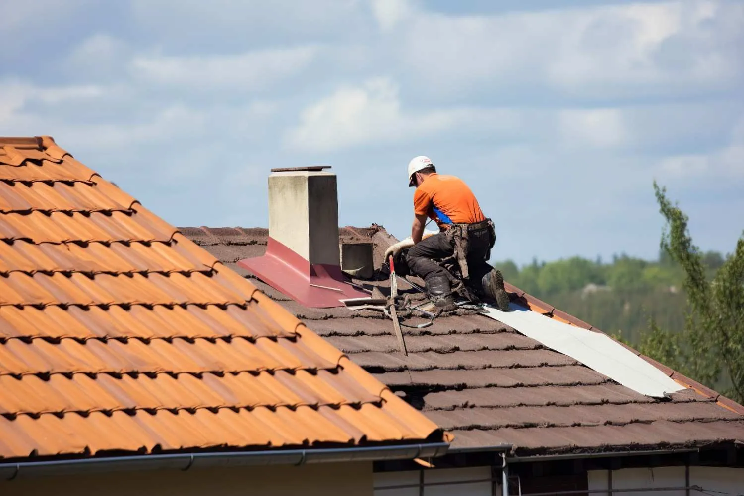 Roofer repairing shingles on a residential roof
